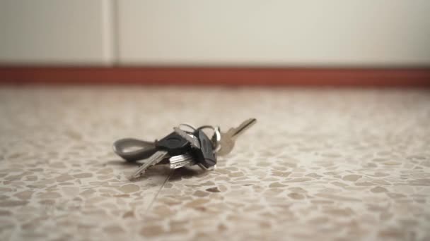 Ένα μάτσο κλειδιά πέφτουν στο πάτωμα και μετά τα παίρνουν. — Αρχείο Βίντεο