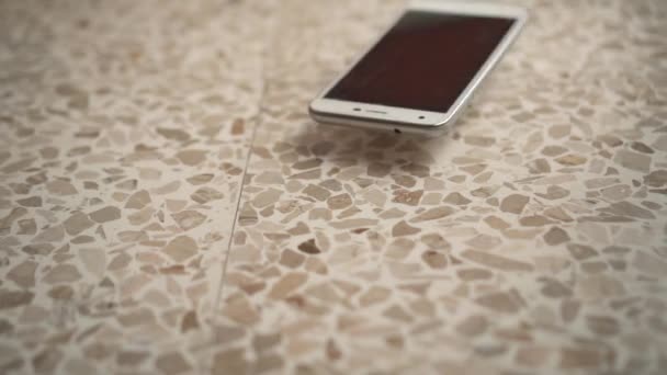 Телефон падає на підлогу і піднімається — стокове відео