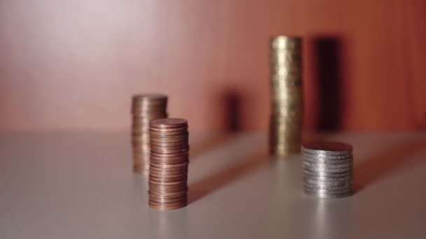 Monedas colocadas en grupos sobre un mueble e iluminadas por una luz — Vídeo de stock