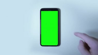 Akıllı telefonun yeşil ekranında el hareketleri yapar.