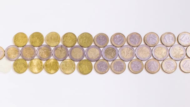 Las monedas aparecen en la superficie blanca — Vídeos de Stock