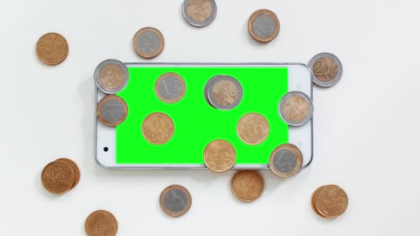 Smartphone with green screen with coins around — Stock Video