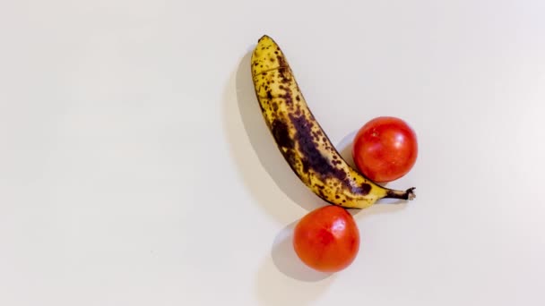 Dos tomates con plátano en el medio — Vídeo de stock