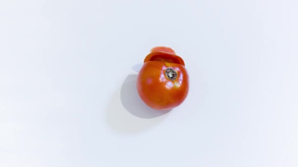 Un tomate se corta en trozos — Vídeo de stock