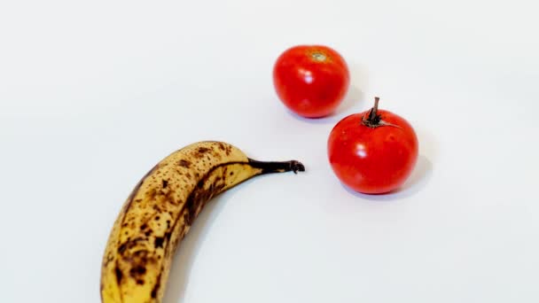 Банана посеред двох помідорів. — стокове відео