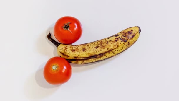 Plátano en medio de dos tomates — Vídeos de Stock