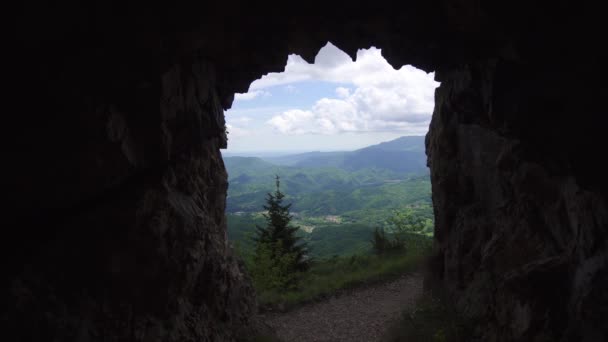 Pohled na zelené kopce z temné jeskyně — Stock video