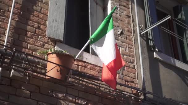 Bandera italiana ondeando en el balcón de la antigua casa — Vídeo de stock