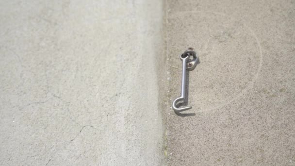 На бетонной стене висит дверной крючок — стоковое видео