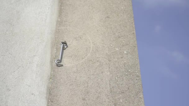 На бетонной стене висит дверной крючок — стоковое видео