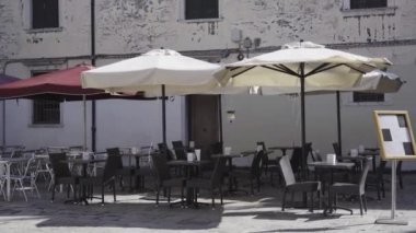 Açık restoran masaları ve sandalyeler.