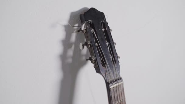 Vecchia chitarra appoggiata sulla parete bianca — Video Stock