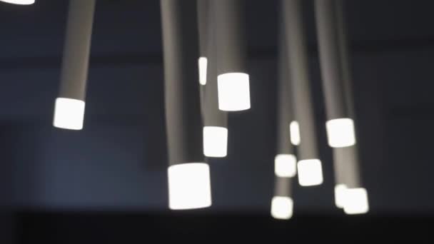 Stijlvolle lampen met buizen en gloeilampen schommelen op celling — Stockvideo