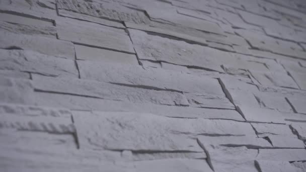 Beweging langs grijze stenen muur met kleine bakstenen als decoratie — Stockvideo