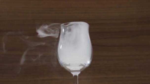Dym odlatuje od kieliszka na brązowym tle zbliżenie — Wideo stockowe