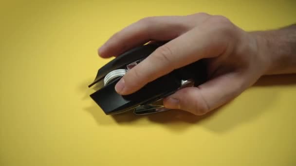 Мужчина играет с оптической игровой мышью на ярко-желтом — стоковое видео