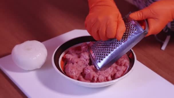 La cebolla se ralla con el rallador dentro de la carne cruda picada — Vídeo de stock