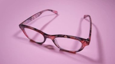 açık pembe arka planda şık kadın gözlükleri.