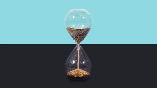 Sandglass com derramamento de areia dourada em azul e preto — Vídeo de Stock