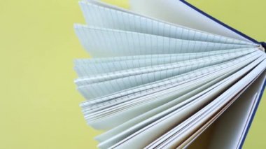 Sarı arkaplanda üst görünümü olan açık bir defter
