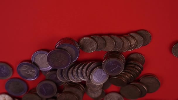 Monedas esparcidas sobre la mesa roja — Vídeo de stock
