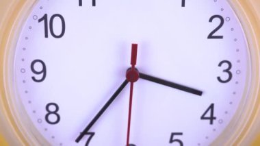 Ön plandaki sarı duvardaki saat.