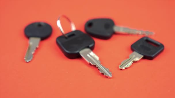 Uppsättning bilnycklar med svarta huvuden ligger på orange bakgrund — Stockvideo