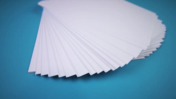 Branco folhas de papel vazias ventilador no fundo azul claro — Vídeo de Stock
