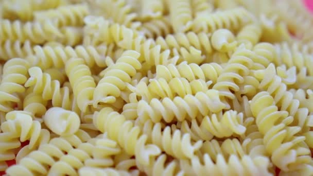 Stor hög med okokt fusilini pasta bitar på röd närbild — Stockvideo