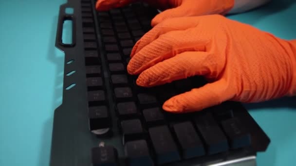 Bewegung um Person in Handschuhen mit Tastatur am blauen Tisch — Stockvideo