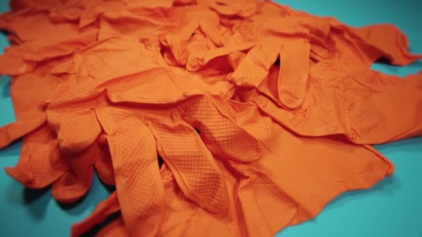 Движение вокруг кучи ярко оранжевых защитных латексных перчаток — стоковое видео