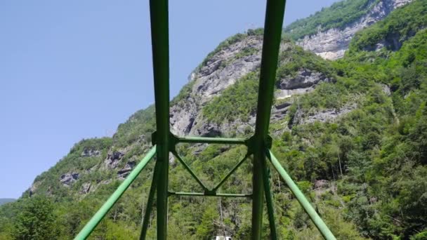 Movimiento bajo las tuberías metálicas que sostienen el puente en las montañas rocosas — Vídeos de Stock