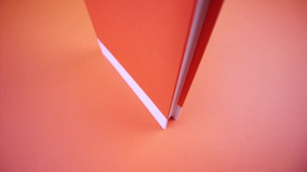 Um livro laranja fechado sobre um fundo laranja — Vídeo de Stock