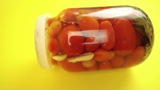 Tarro de tomates cerrados sobre fondo amarillo — Vídeo de stock