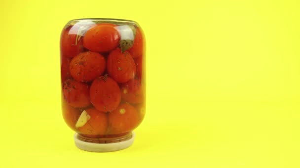 Omgekeerde glazen pot van gesloten tomaten op een gele achtergrond — Stockvideo