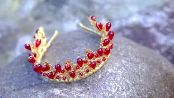 Красная корона для головы на камне в потоке воды — стоковое видео