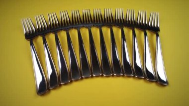 parlak sarı arka planda modern gümüş çatallar yakın plan