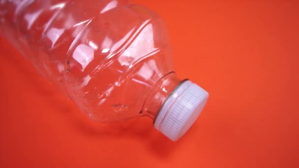 Pohyb kolem prázdné plastové láhve s bílým víčkem na oranžové — Stock video