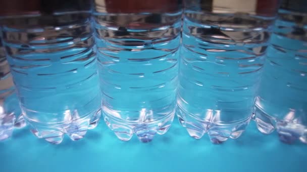 Ligne de bouteilles avec supports d'eau sur fond bleu clair — Video
