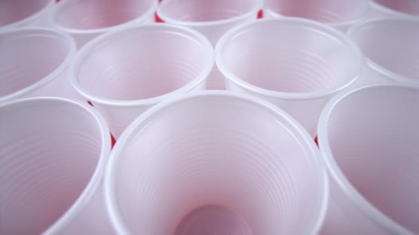 Branco vazio copos descartáveis stand no fundo vermelho closeup — Vídeo de Stock