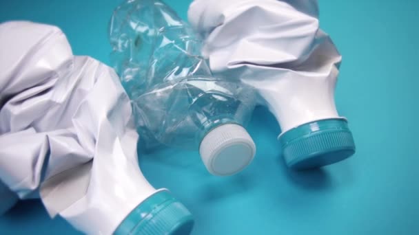 Skrynkliga plastflaskor ligger på ljusblå bakgrund — Stockvideo