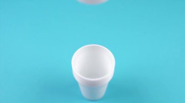 beyaz boş plastik bardaklar açık mavi üzerine yığılır