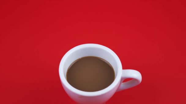 Cup of delicious coffee with milk on bright red background — Stock Video