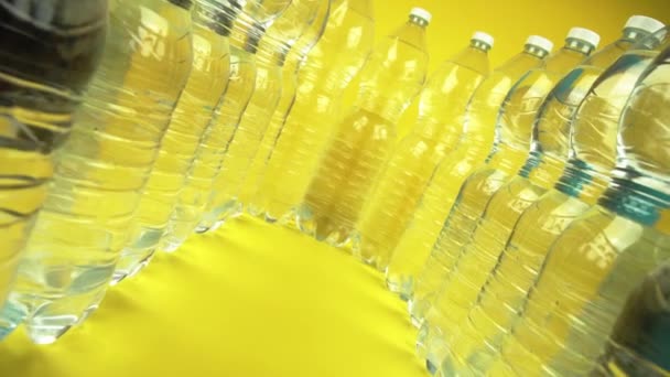Garrafas de água alinhadas em fundo amarelo — Vídeo de Stock