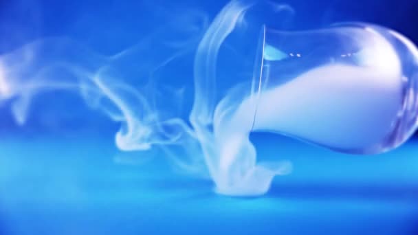 Hälla vit dimma från elegant vinglas på mörkblå — Stockvideo