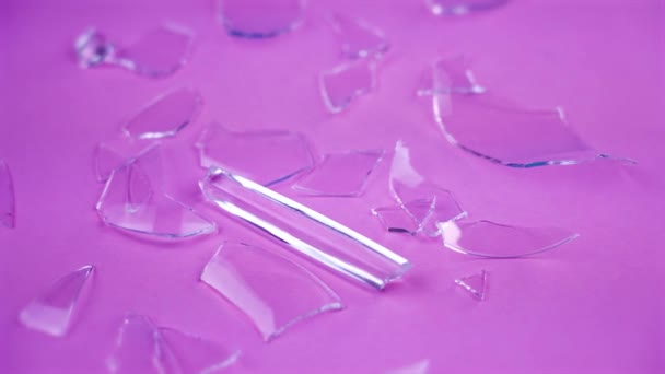 Trozos de vidrio roto en la superficie rosa — Vídeos de Stock