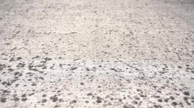 Lekelerle kaplı açık gri betondan yapılmış bir yol.