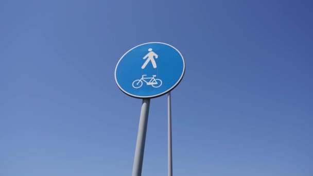 Blue road sign pedestrian and cycle path against blue sky — Stock Video
