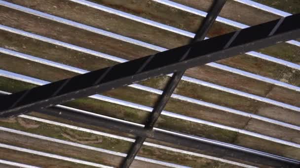 Movimento sob o telhado de madeira do eixo com pólos no dia ensolarado — Vídeo de Stock