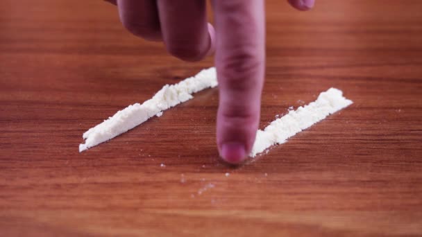 Wit poeder wordt gezogen met de vinger van de hand — Stockvideo